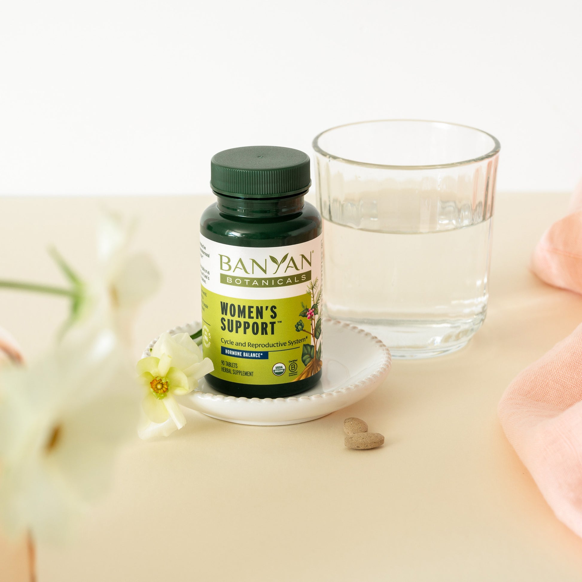 womens support tablets next to glass of water